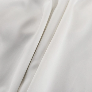 Detailaufnahme von weißem Satinstoff mit luxuriöser glatter Textur und weichem Fall