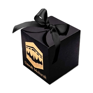 Detail of black Umrah Mubarak gift box with gold Kaaba foil and satin ribbon bow