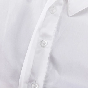 Detalle de vestido camisero blanco que muestra cuello de solapa y botones de tela de algodón