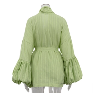 Détail du cardigan en coton vert clair avec manches bouffantes et tissu à fines rayures