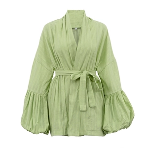 Détail du tissu en coton texturé vert clair avec ceinture à nouer et manches bouffantes