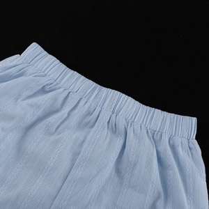 Détail de la taille élastique d'un short en coton bleu clair ajouré avec texture