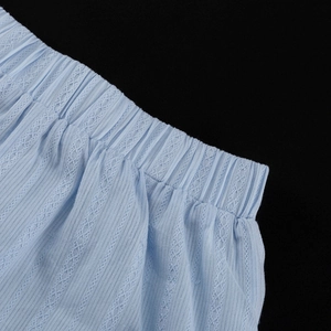 Détail de la taille élastique bleu clair avec tricot ajouré en dentelle et tissu côtelé