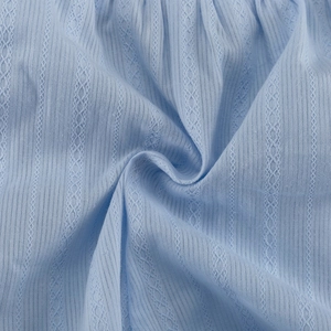 Vue détaillée du tissu jacquard bleu clair avec des motifs de dentelle verticaux