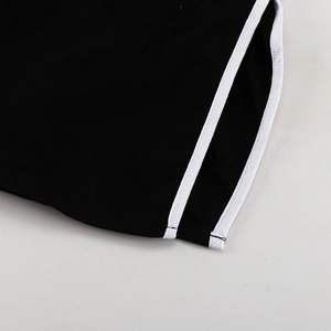 Detailopname van zwarte gebreide stof met witte dubbele biezen op een set met V-hals