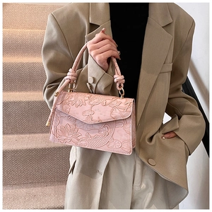 Detail of pink leather handbag featuring 3D embossed lotus and koi fish patterns