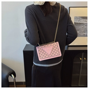 Detailansicht der pink-braunen Umhängetasche mit M-Buchstaben-Print an einem Modell