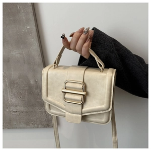 Détail d'un sac à main élégant en cuir crème avec fermoir doré et poignée chic