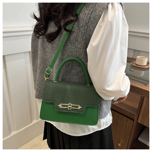 Detail of green crossbody bag with textured flap and elegant gold metal buckle closure