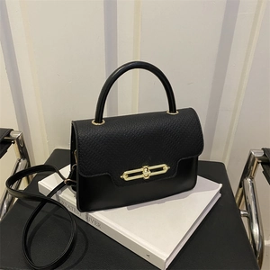 Detail of black leather box bag featuring lychee texture and gold chain link lock