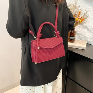 Minimalist woven shoulder bag in deep pink with knotted handle and gold hardware