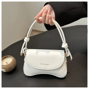 Detail of white matte PU leather bag featuring a unique concave base and knotted handle
