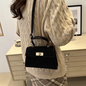 Sac bandoulière noir mat minimaliste avec boucle dorée pour femme au style moderne