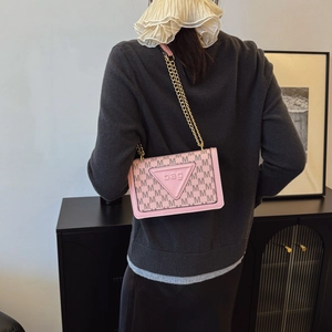 Borsa a spalla rosa con catena dorata e stampe a lettere indossata da modella in interno