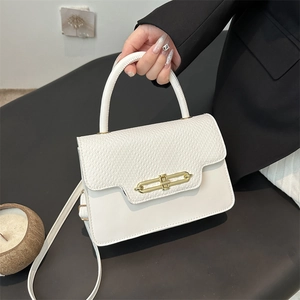 White textured leather box bag with gold metal clasp and crossbody strap