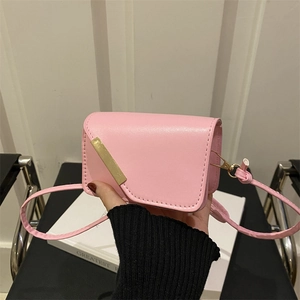 Dettaglio della mini borsa a tracolla rosa opaco con decorazione rettangolare dorata