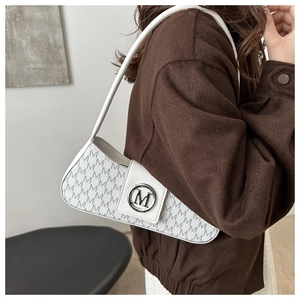 Detail of white monogram shoulder bag featuring a silver M logo and textured PU leather