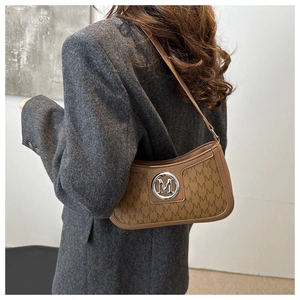 Detail of vintage monogram shoulder bag with silver logo on a brown leather trim