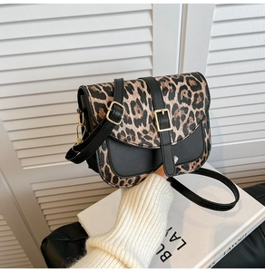 Detail of leopard print patchwork shoulder bag with gold buckle and adjustable strap