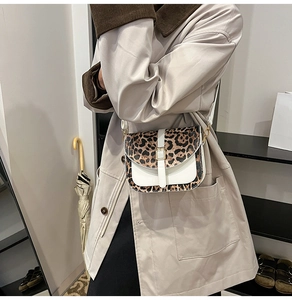 Detail of leopard print patchwork crossbody bag with golden metal buckle on model