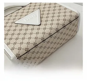 Close-up of leather stitching and logo detail on beige monogram shoulder bag