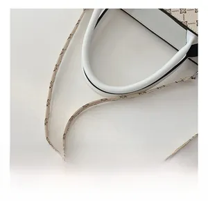 Detail of vintage floral pattern on tote bag with white leather handles and strap