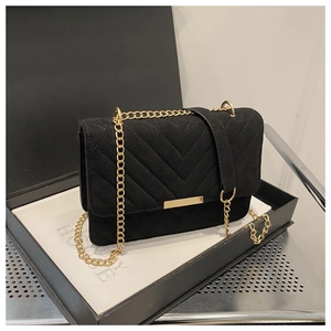 Close-up of black suede crossbody bag with V-shaped quilting and gold metal trim