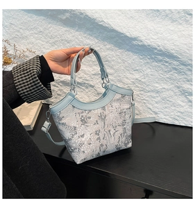 Detail of silk embroidery handbag featuring floral patterns and silver hardware