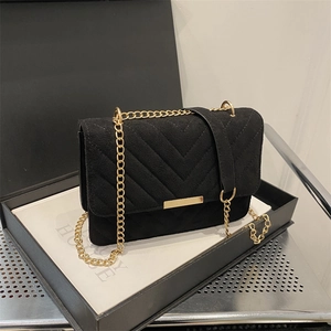 Minimalist black quilted crossbody bag with gold chain strap in a premium gift box setup