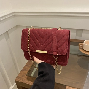 Elegant burgundy quilted suede chain bag with gold metal accents and V-shaped stitching