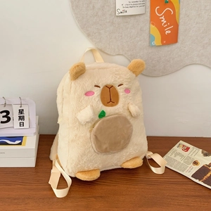 Close-up of fluffy Capybara plush backpack with embroidery and leaf zipper on desk