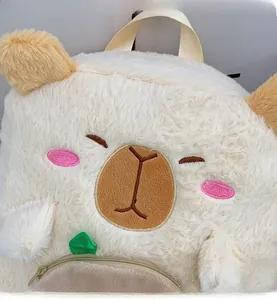 Detailed view of plush capybara backpack featuring embroidery and a green leaf detail