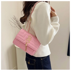 Detail of pink quilted flap bag with gold chain strap and decorative tassel