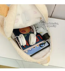 Spacious interior of the plush capybara backpack showing books, headphones and a tablet