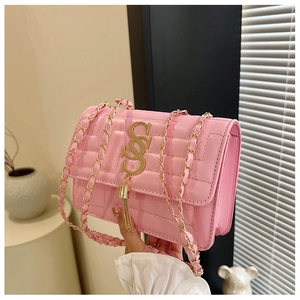 Detail of pink quilted leather shoulder bag with gold tassel and metal chain strap