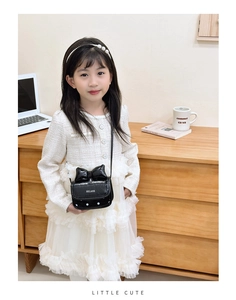 Bolso bandolera de charol negro para niña con lazo decorativo y detalles de lunares blancos