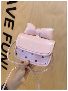 Detalle de bolso mini rosa con un lazo grande y un patrón de lunares negros