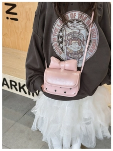 Detalle de bolso rosa para niña con lazo decorativo y motivos de lunares negros