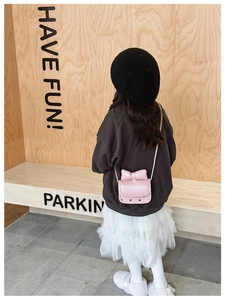 Mini bolso bandolera rosa para niñas con lazo decorativo visto desde atrás