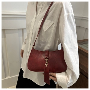 Close-up of retro red leather underarm bag featuring a stylish large golden buckle