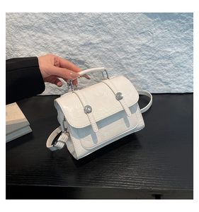 Détail du petit sac blanc vintage texturé avec boucles argentées et bandoulière fine