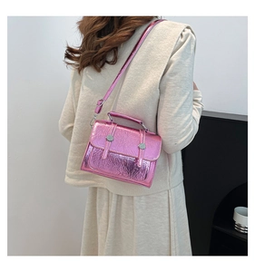 Sac bandoulière rose métallisé avec texture plissée et boucles argentées sur la bandoulière
