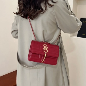 Red quilted faux leather crossbody bag with gold S-buckle and elegant chain strap