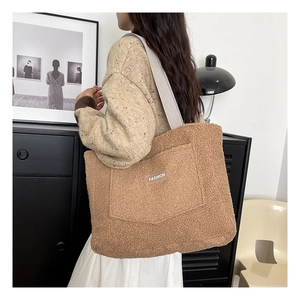 Dettaglio della grande borsa tote in peluche marrone con tasca frontale e etichetta moda
