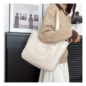 Dettaglio di borsa tote in peluche bianca con ricamo fashion e morbida texture teddy