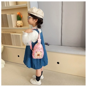 Rosa Kinder Brusttasche mit Wasserschwein-Motiv Rückansicht am Model im gemütlichen Raum