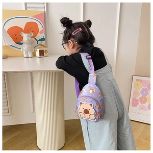 Detail einer lila Kinder-Brusttasche aus Canvas mit süßem Wasserschwein-Cartoon-Druck
