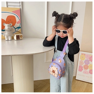 Detailansicht der lila Kinder-Umhängetasche mit Bärenmotiv, von einem Mädchen getragen