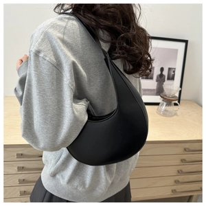 Minimalist black crescent shoulder bag made of smooth matte faux leather for daily commuting