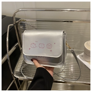 Detail of silver crossbody bag featuring pink cartoon bear print and magnetic flap closure